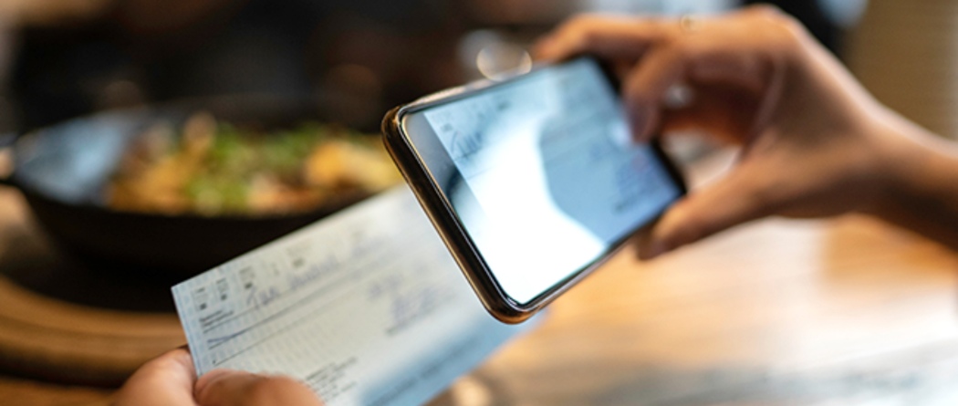 a person taking a picture of a paper check