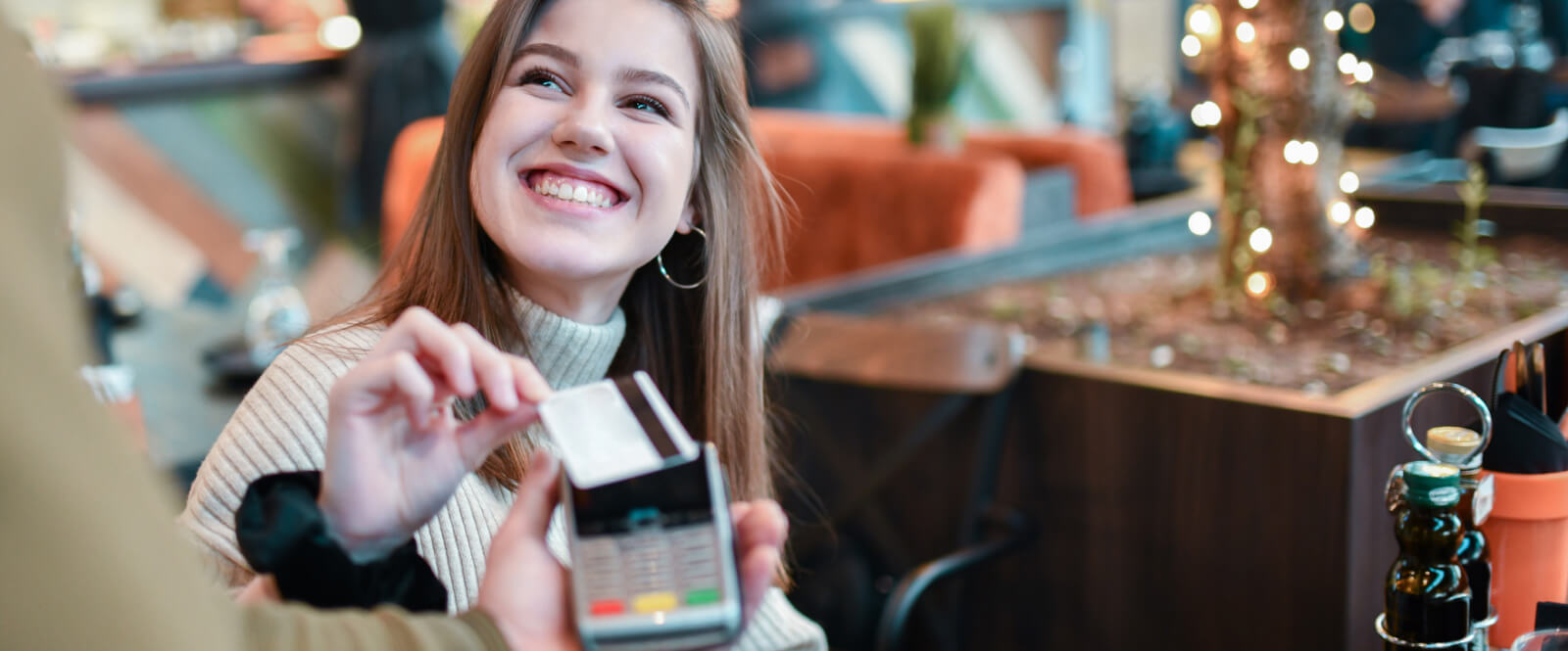 A woman holding a credit card up to a card processor